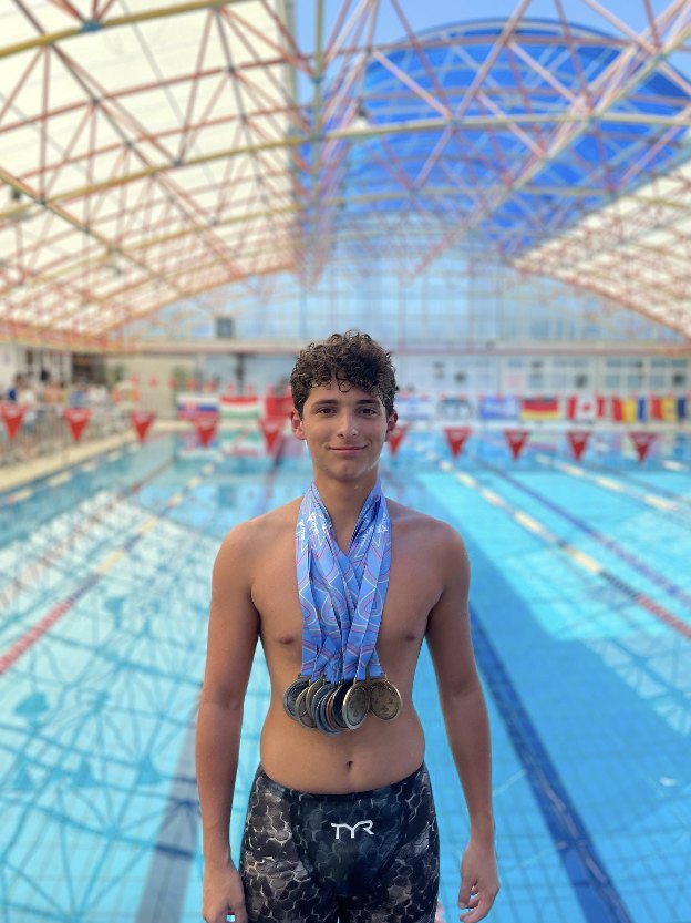 Phoenix swimmer with a stack of medals at an international meet